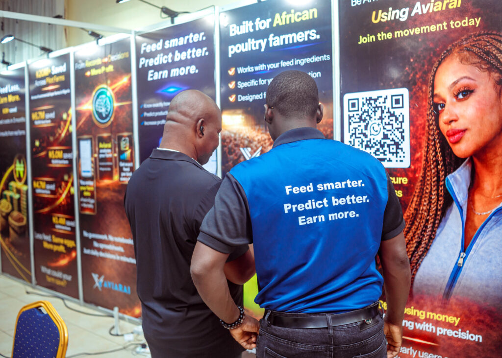 Aviarai team member discussing the poultry intelligence platform with an attendee beside the “Feed smarter. Predict better. Earn more.” display.