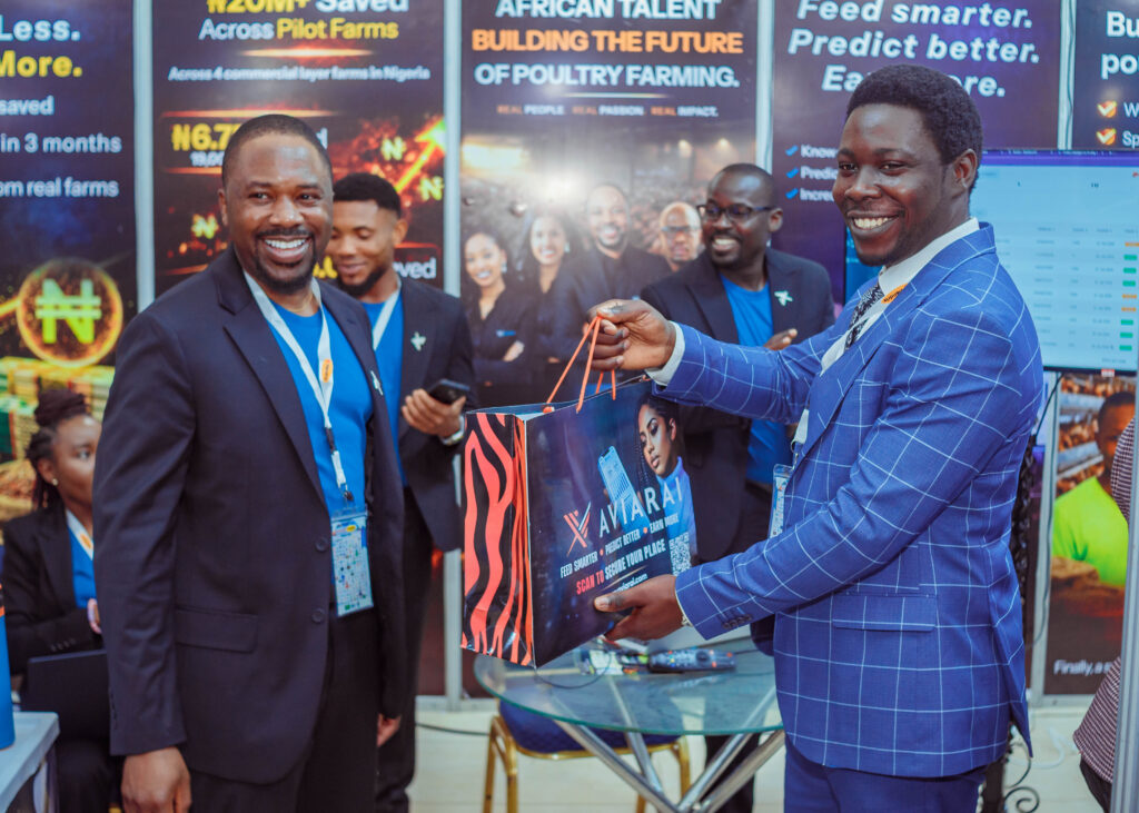 Aviarai representative with an exhibition attendee holding a branded Aviarai bag at a poultry industry event.