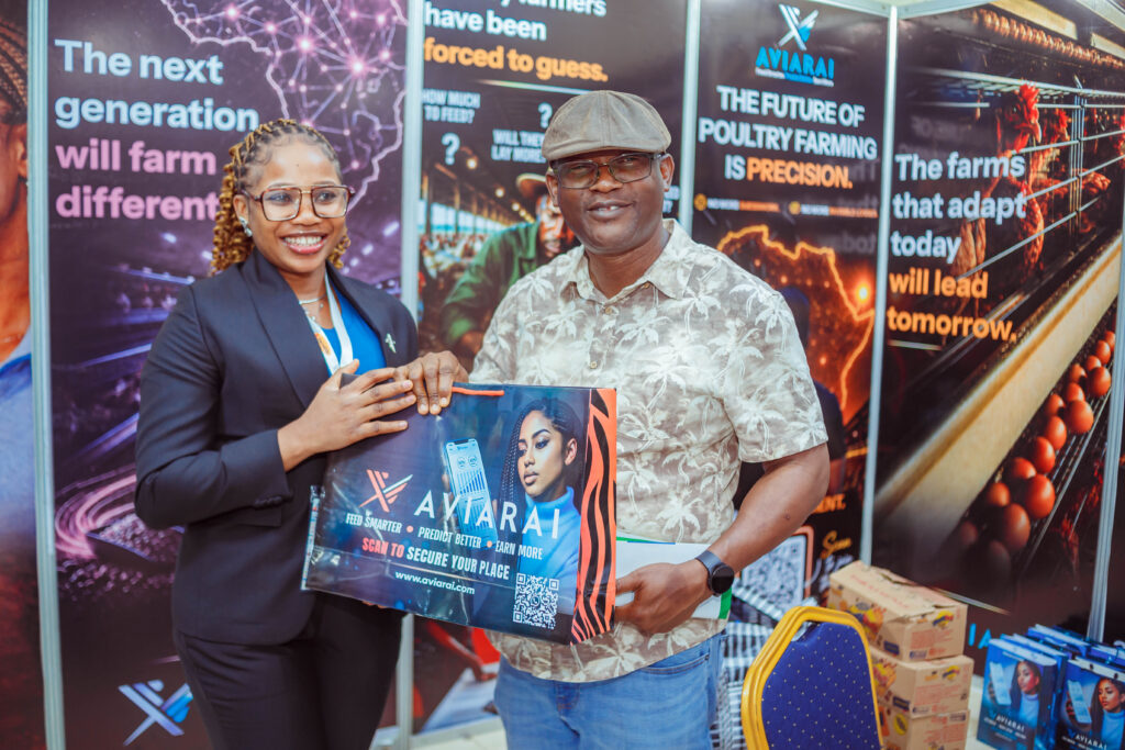 Aviarai team member presenting a branded Aviarai bag to a poultry industry exhibition attendee.